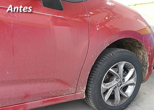 Lateral de um carro vermelho sujo, com poeira e respingos de barro na roda, antes da lavagem no Lava-Rápido DK